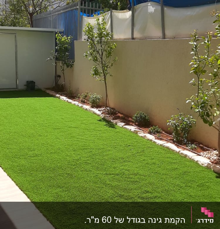 דשא סינתטי, עצים קטנים, ערוגת פרחים לצד קיר